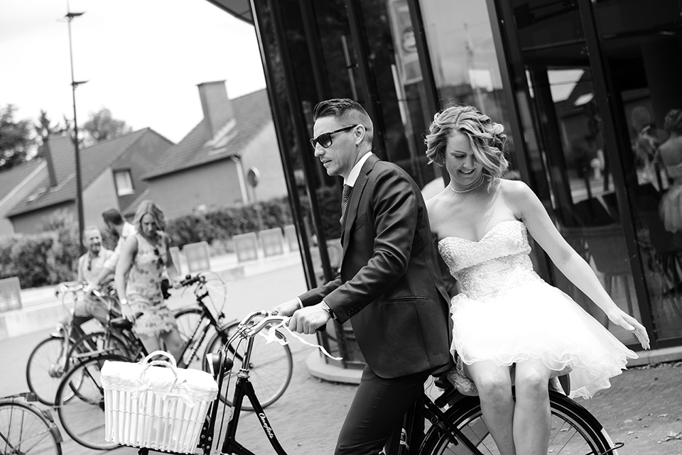 Bouquet of paper and bride and groom on bicycle